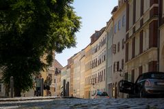 Charming cobblestone street with historic buildings and lush tree in Görlitz, Sachsen.