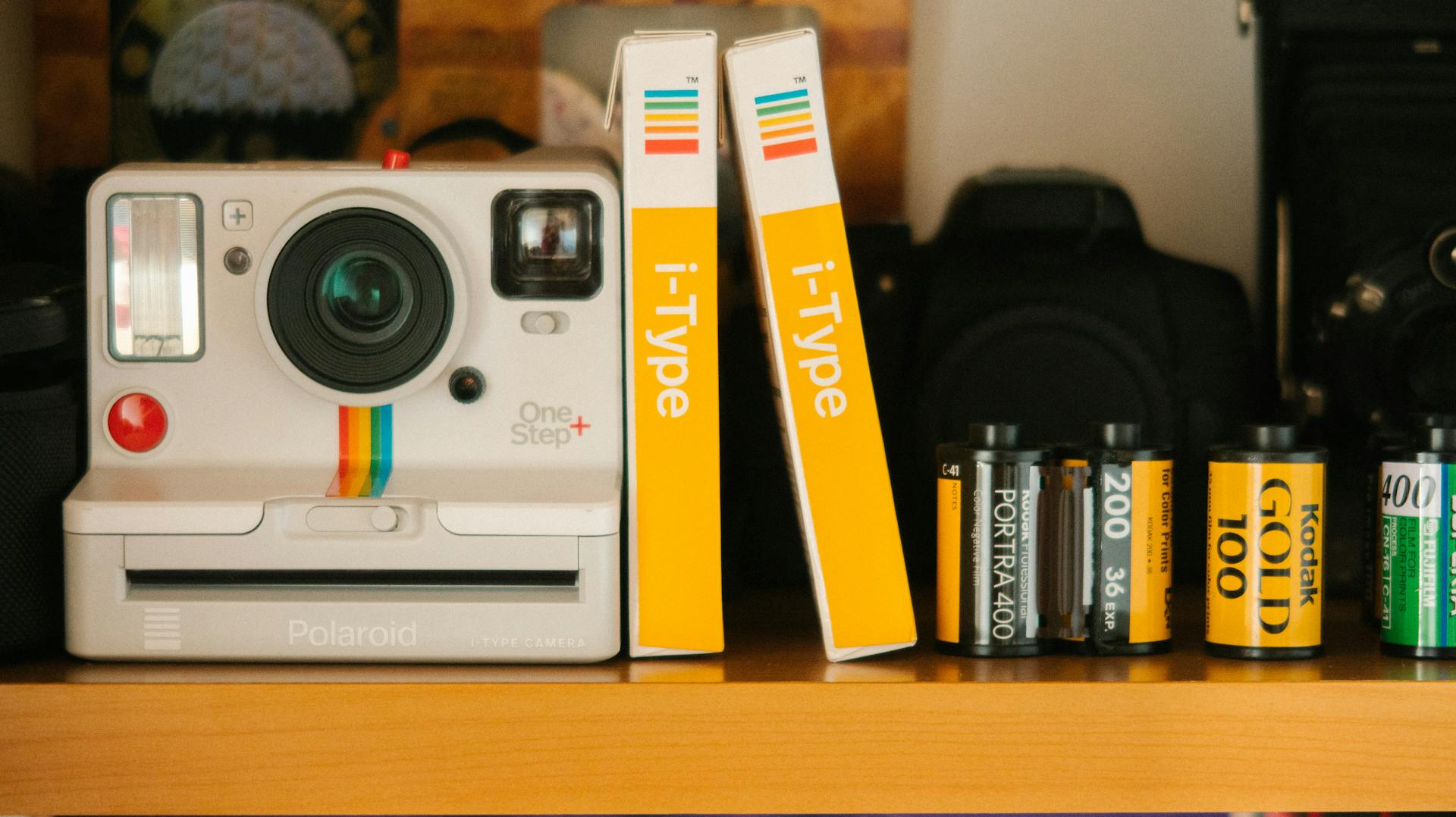 White Polaroid Land Camera Beside Photo Paper Boxes and Photo Films