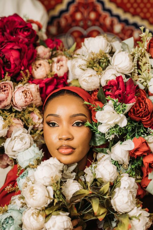 Free Captivating portrait of a woman surrounded by vibrant flowers, exuding grace and beauty. Stock Photo