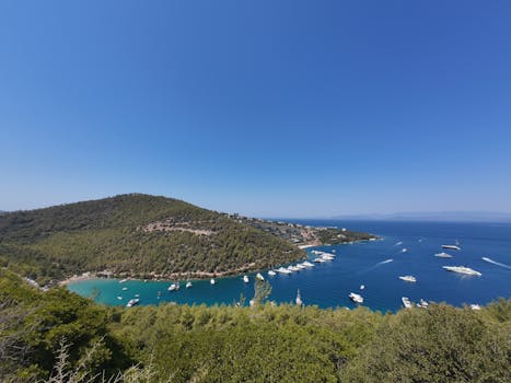 一个宁静的沿海海湾，航拍照片令人惊叹；游艇在清澈蓝天下，适合旅行旅游主题