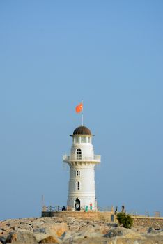 海滨灯塔，蔚蓝的天空和岩石的前景构成了一幅美丽的画面