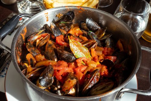 Free Close-up of mussels in tomato sauce served in a pot, showcasing authentic French cuisine. Stock Photo
