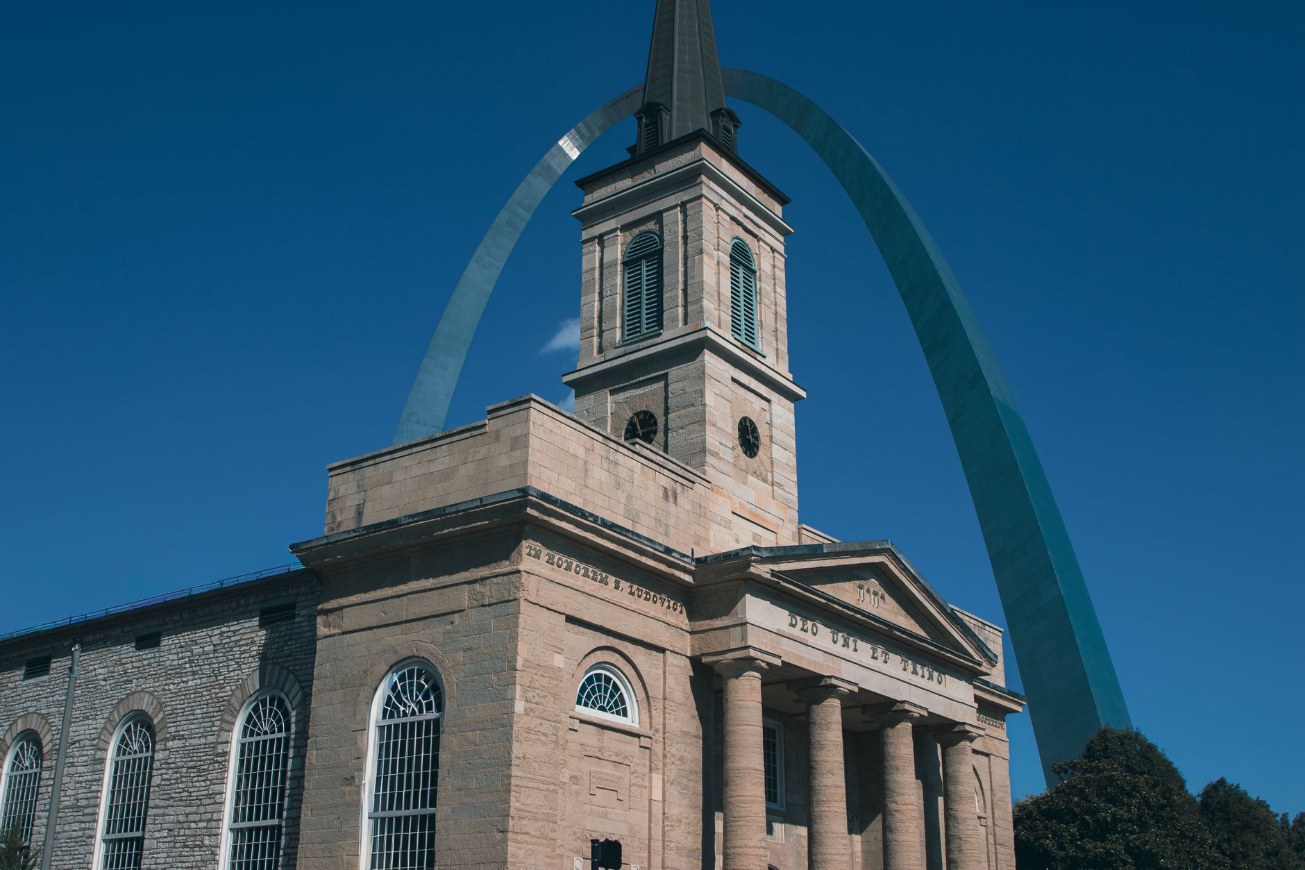 Historic cathedral and Gateway Arch on a sunny day in St. Louis.