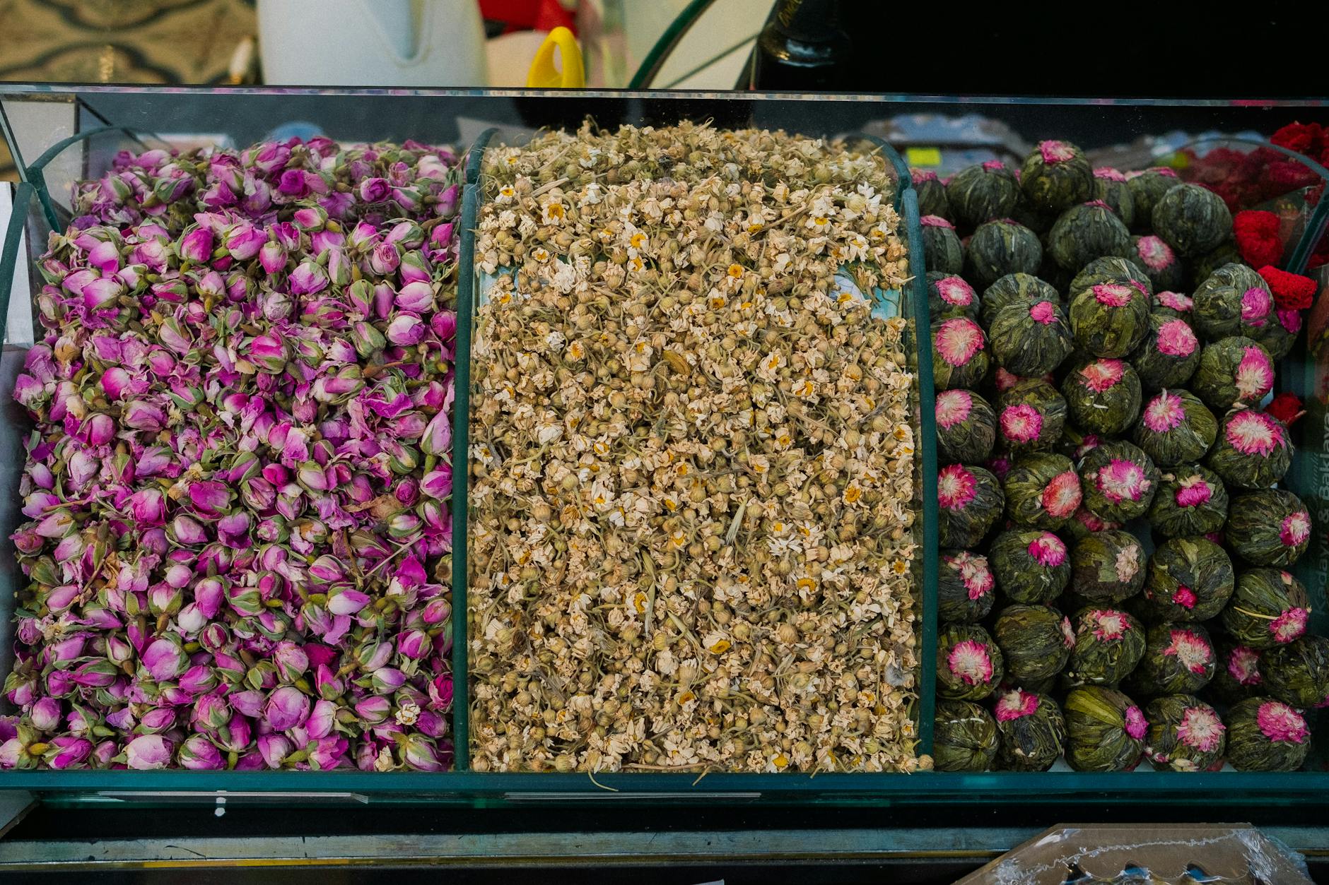 Sindirimi rahatlatan ve gaz gideren şifalı bitki karışımları ile hazırlanmış bir fincan sıcak bitki çayı ve yanındaki kurutulmuş bitkiler.