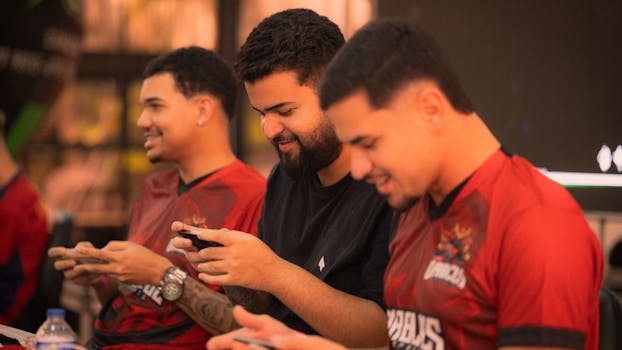 Group of young men focused on gaming with smartphones in an indoor setting.