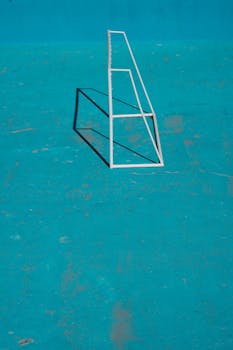 An abstract image featuring a geometric shadow on a turquoise surface, highlighting minimalism.