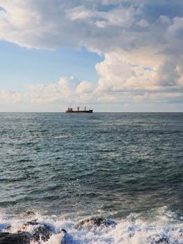 一艘货船在公海上航行，天空和云层都清晰可见