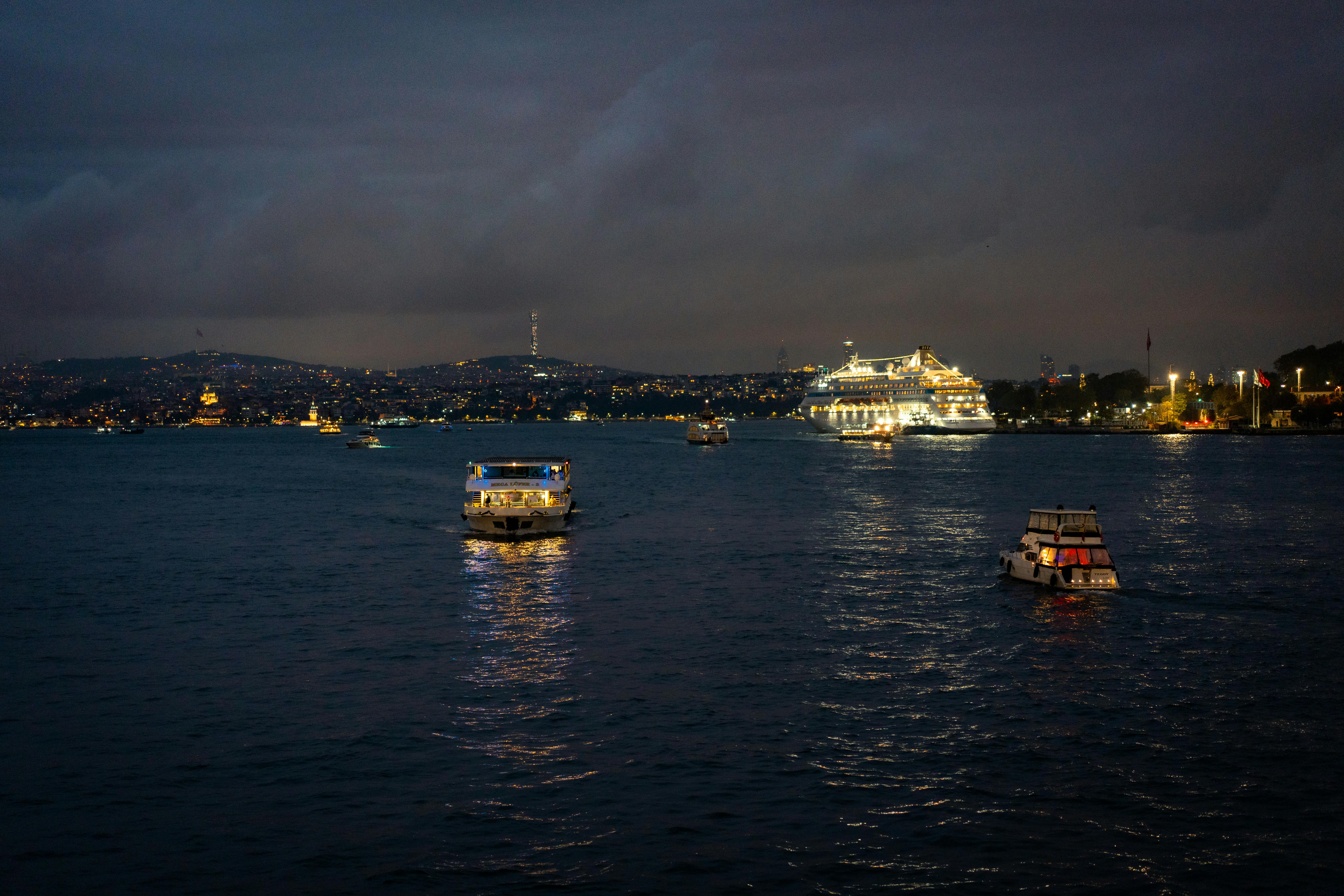 在博斯普鲁斯海峡的夜晚，船的风景与城市灯光形成对比