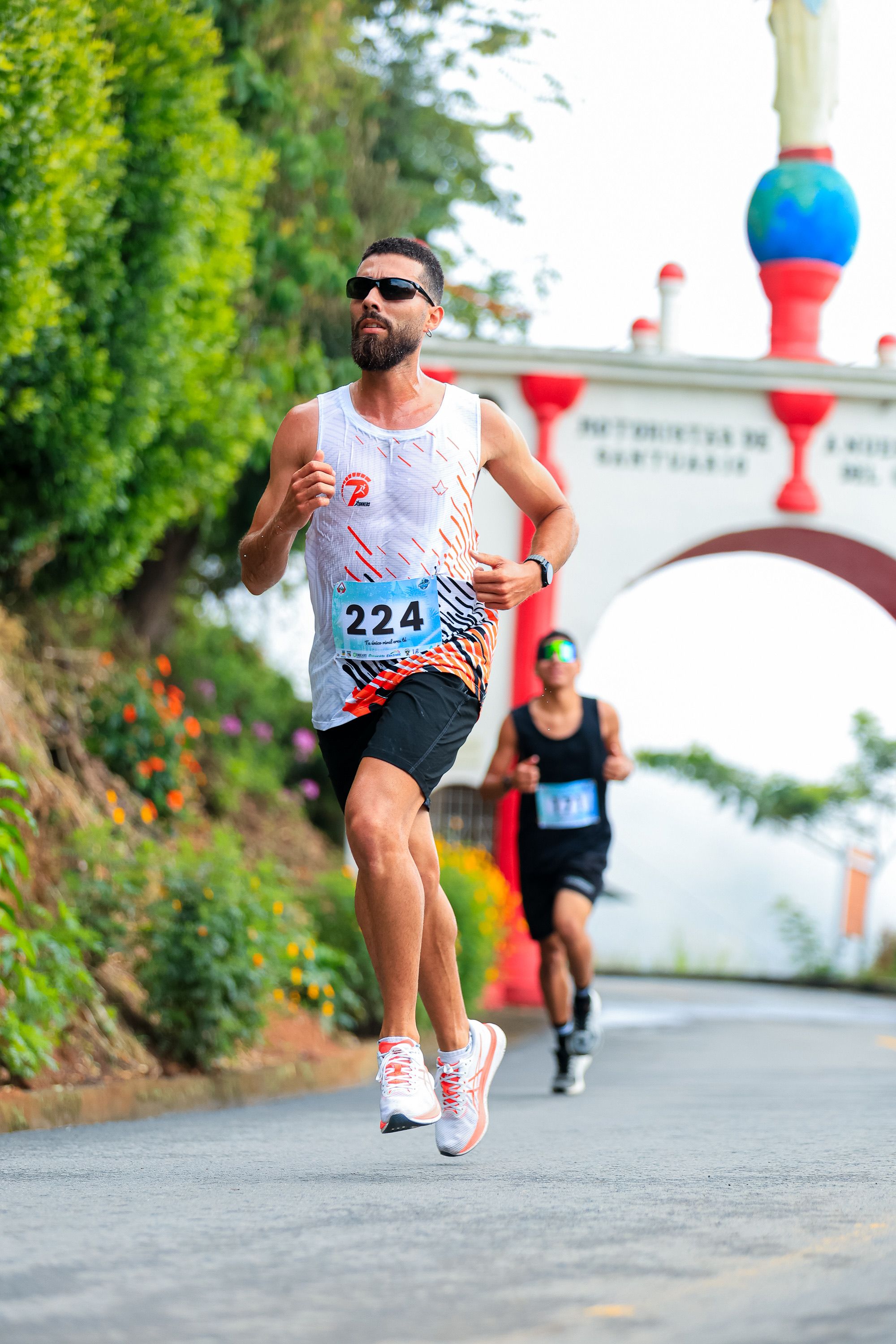 Dynamic Runners Passing Under Scenic Archway · Free Stock Photo