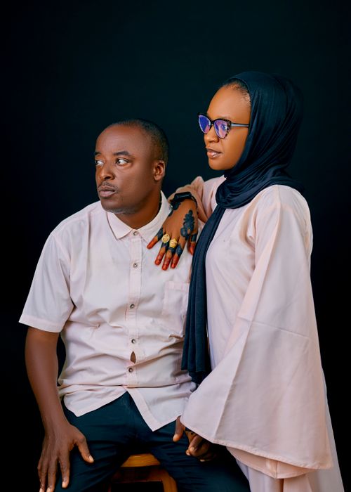 Free Elegant portrait of a couple in traditional attire with a dark background. Stock Photo