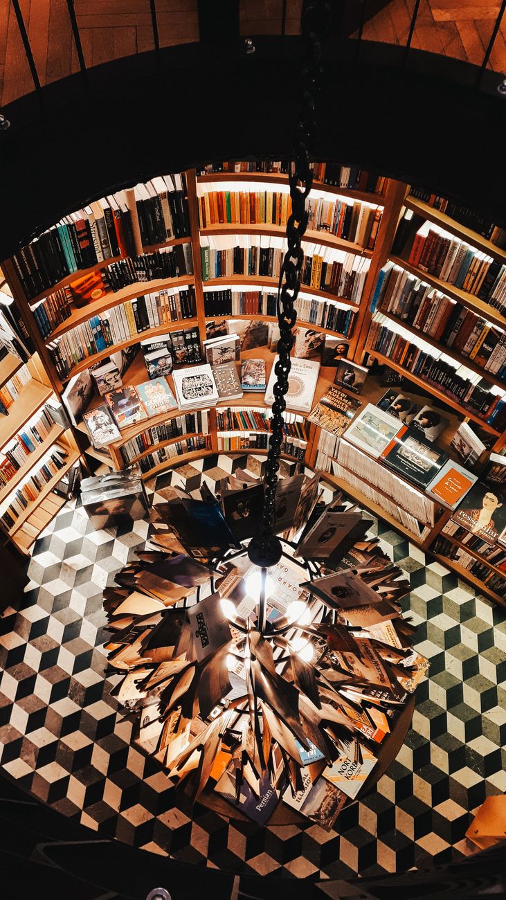 Discover a stunning aerial view of a cozy bookstore in Beşiktaş, Istanbul, filled with books under a unique chandelier.
