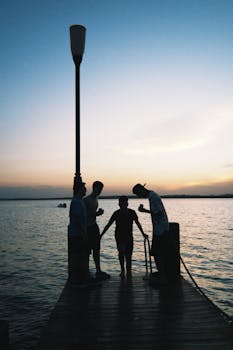 一群朋友在湖滨码头上，在日落的天空映衬下捕捉到了宁静的时刻