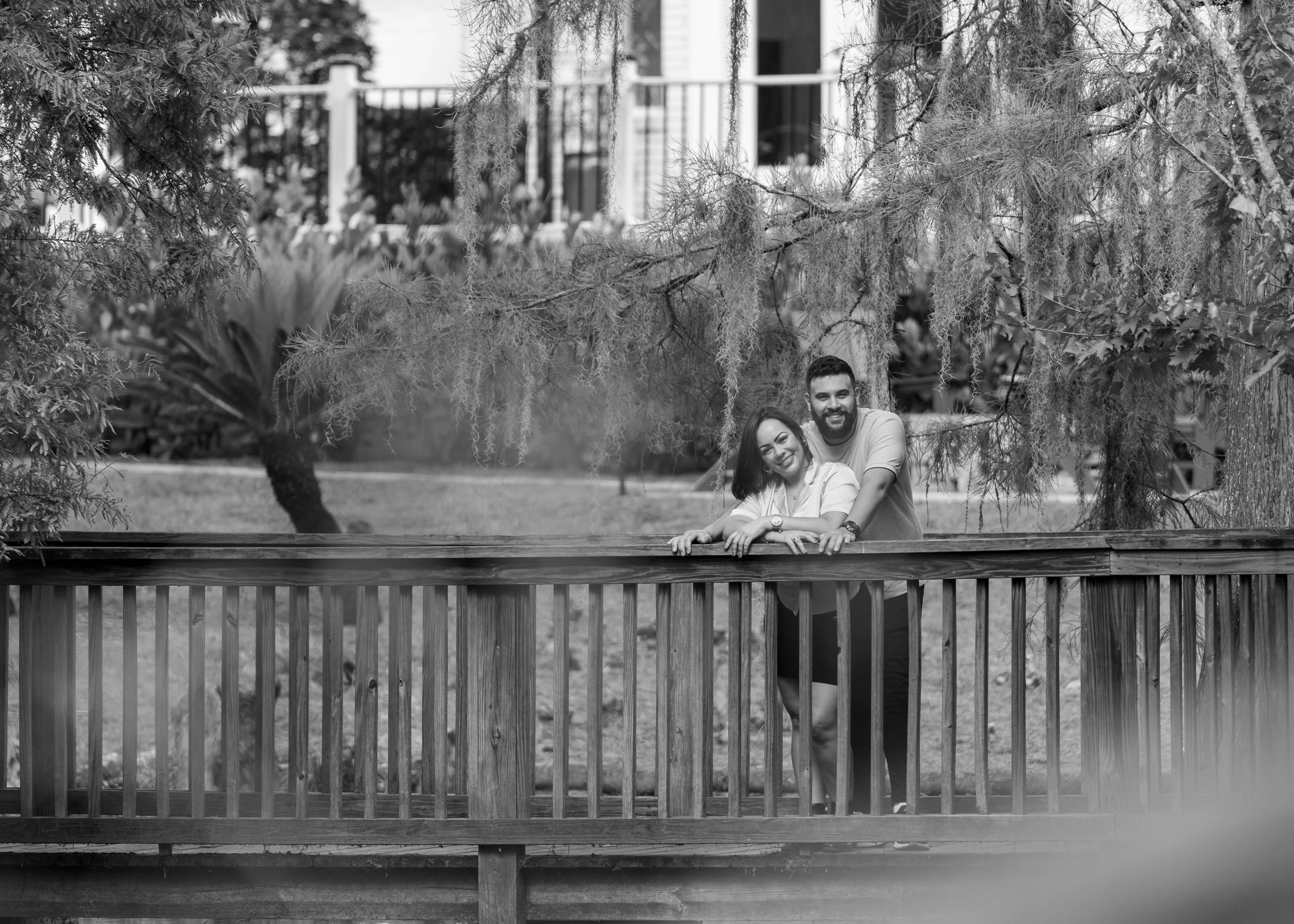 Безкоштовне Пара обіймається на дерев'яному мосту в спокійному парку. стокове фото