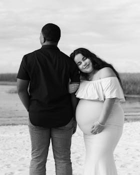 情侣在海滩上享受着黑白相间的宁静，同时怀孕的时刻