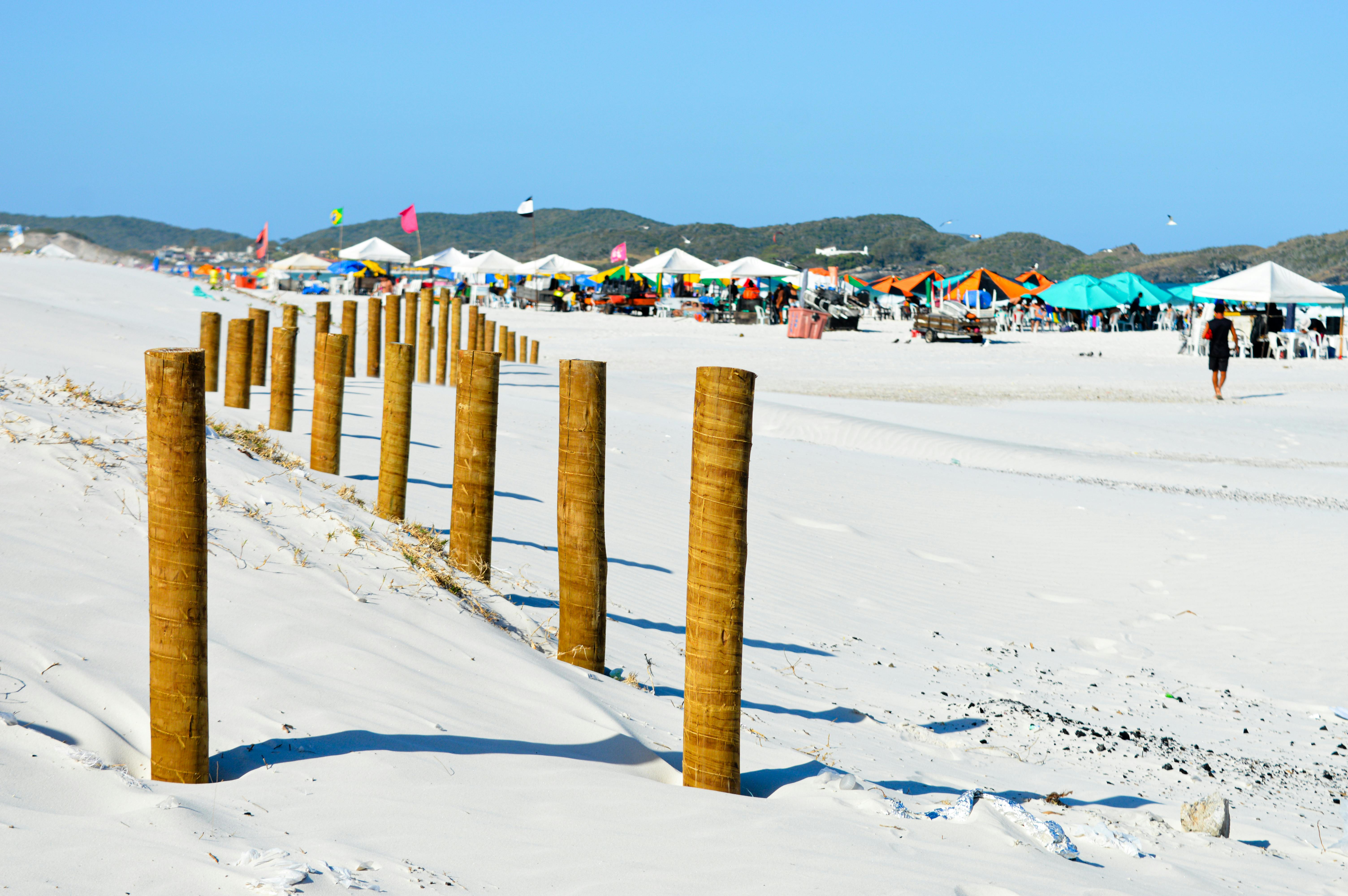 Beautiful white sand beach in Rio de Janeiro, showcasing colorful tents with a backdrop of lush green hills.