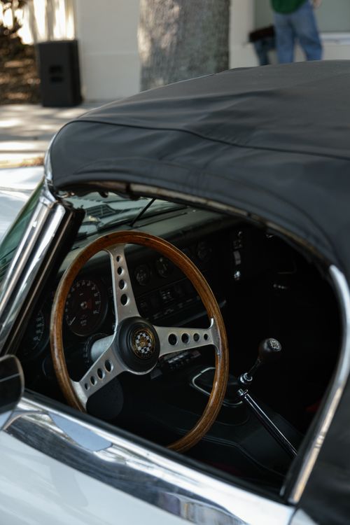 Free Close-up view of a classic car's interior featuring a wooden steering wheel and elegant dashboard. Stock Photo
