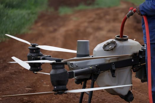 Close-up view of a drone being filled with liquid for agricultural purposes.