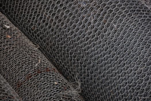 Detailed view of rolled metal wire mesh showcasing intricate patterns, ideal for industrial and construction themes.