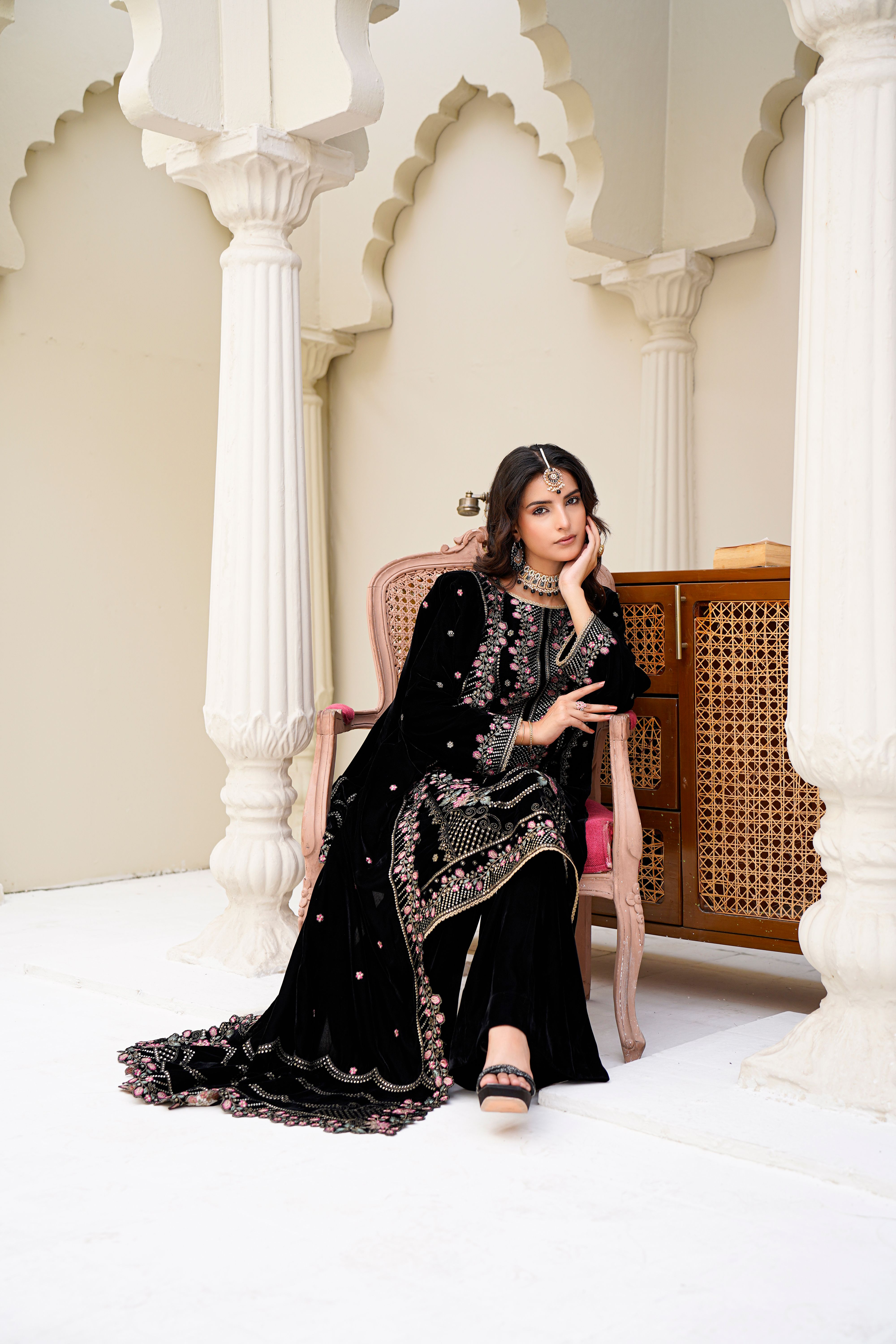 Graceful woman in traditional Eastern attire sitting elegantly indoors in Lahore, Pakistan.