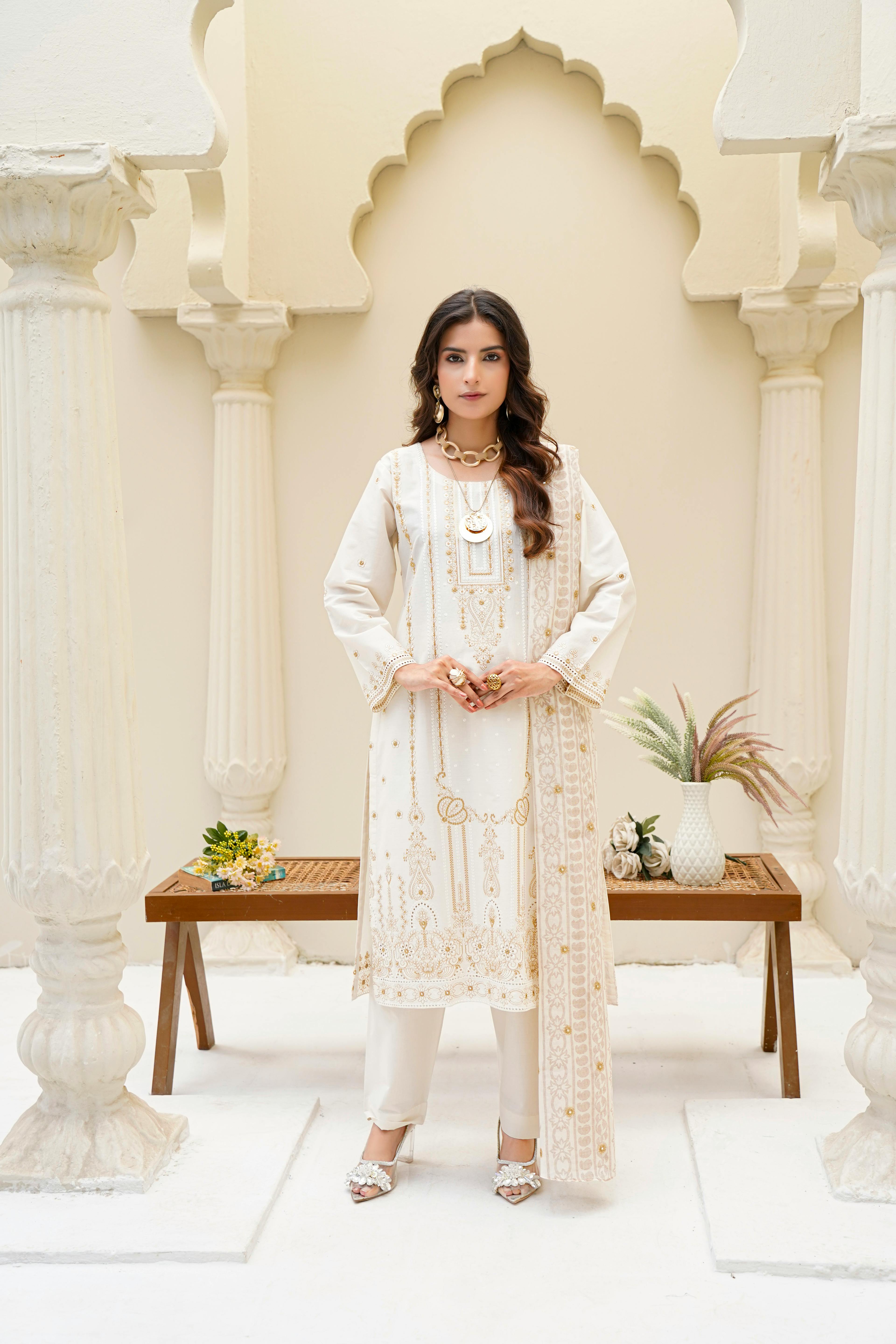 拉合尔的时尚成年女性身着白色刺绣连衣裙，在室内展示传统时尚