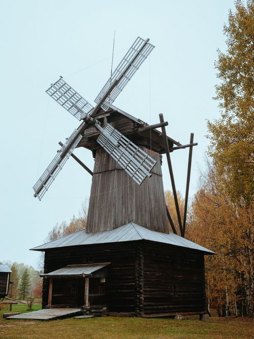 Free Charming rustic wooden windmill surrounded by autumn foliage, showcasing architectural heritage. Stock Photo