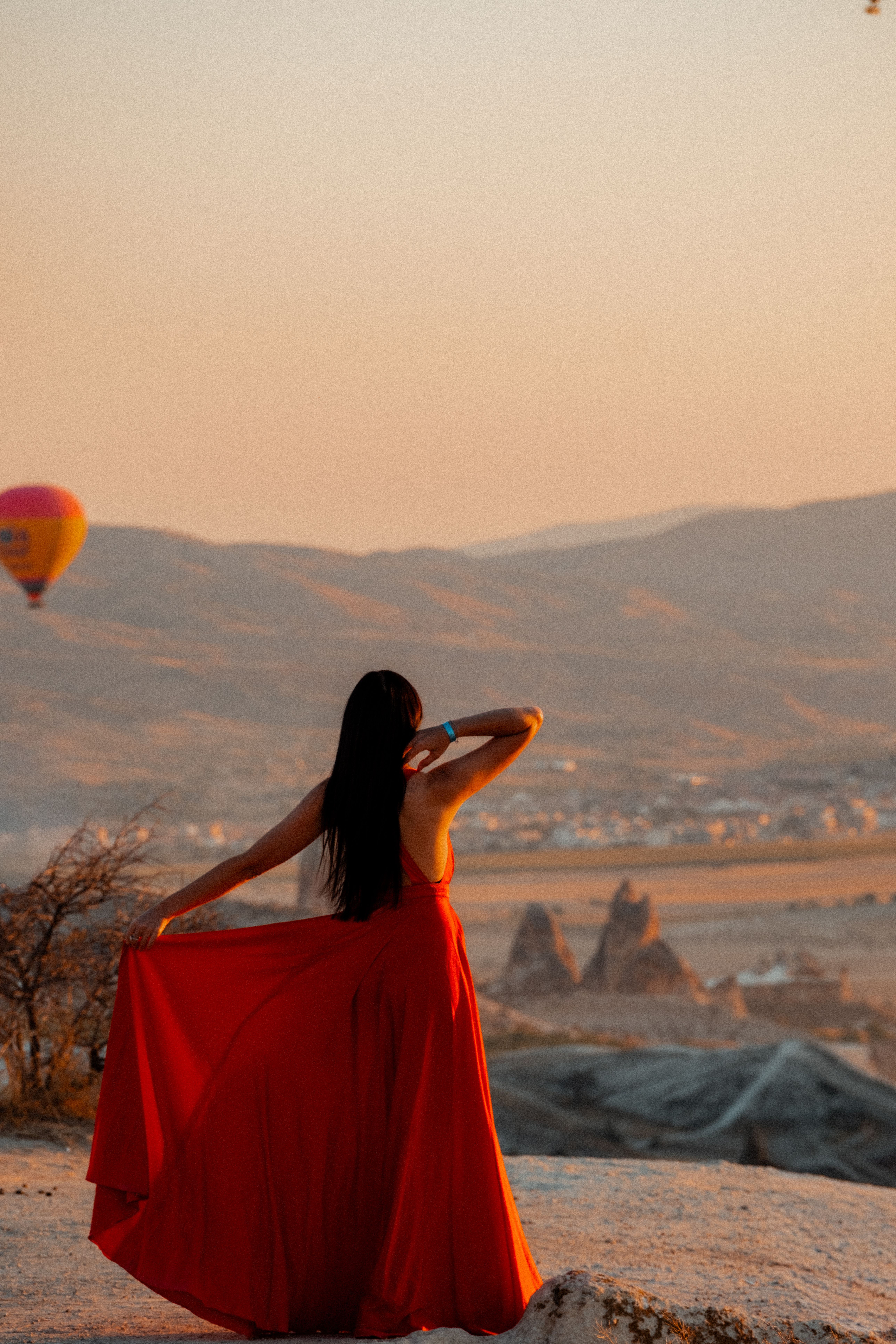 Woman in Red Dress Overlooking Cappadocia Sunset · Free Stock Photo