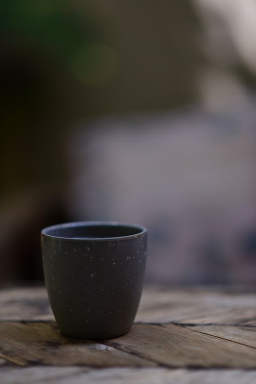 Free Simple ceramic cup on wooden table with blurred background, showcasing minimalist design. Stock Photo