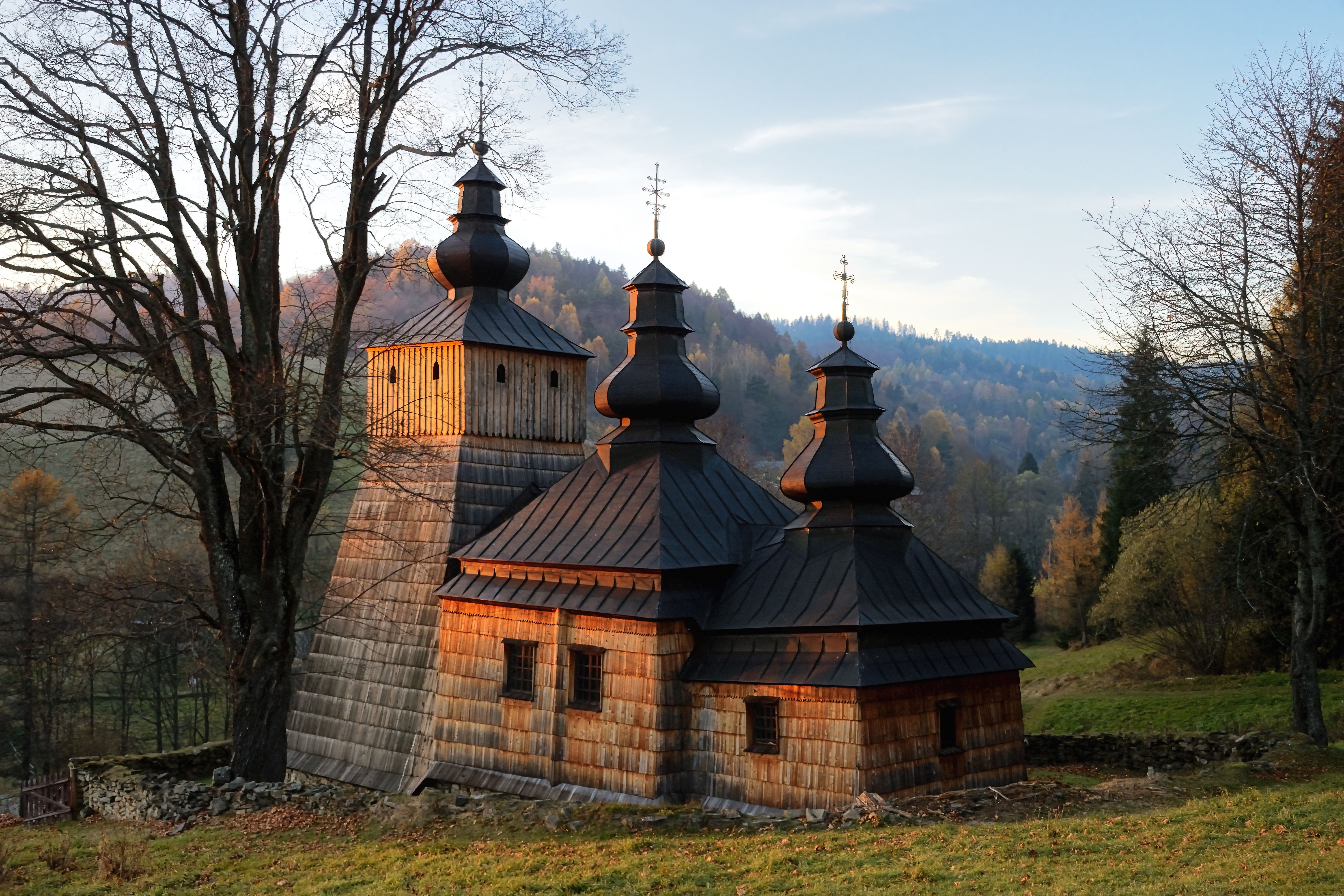 Captivating view of a historic wooden church in Dubne, Poland during a serene sunset.