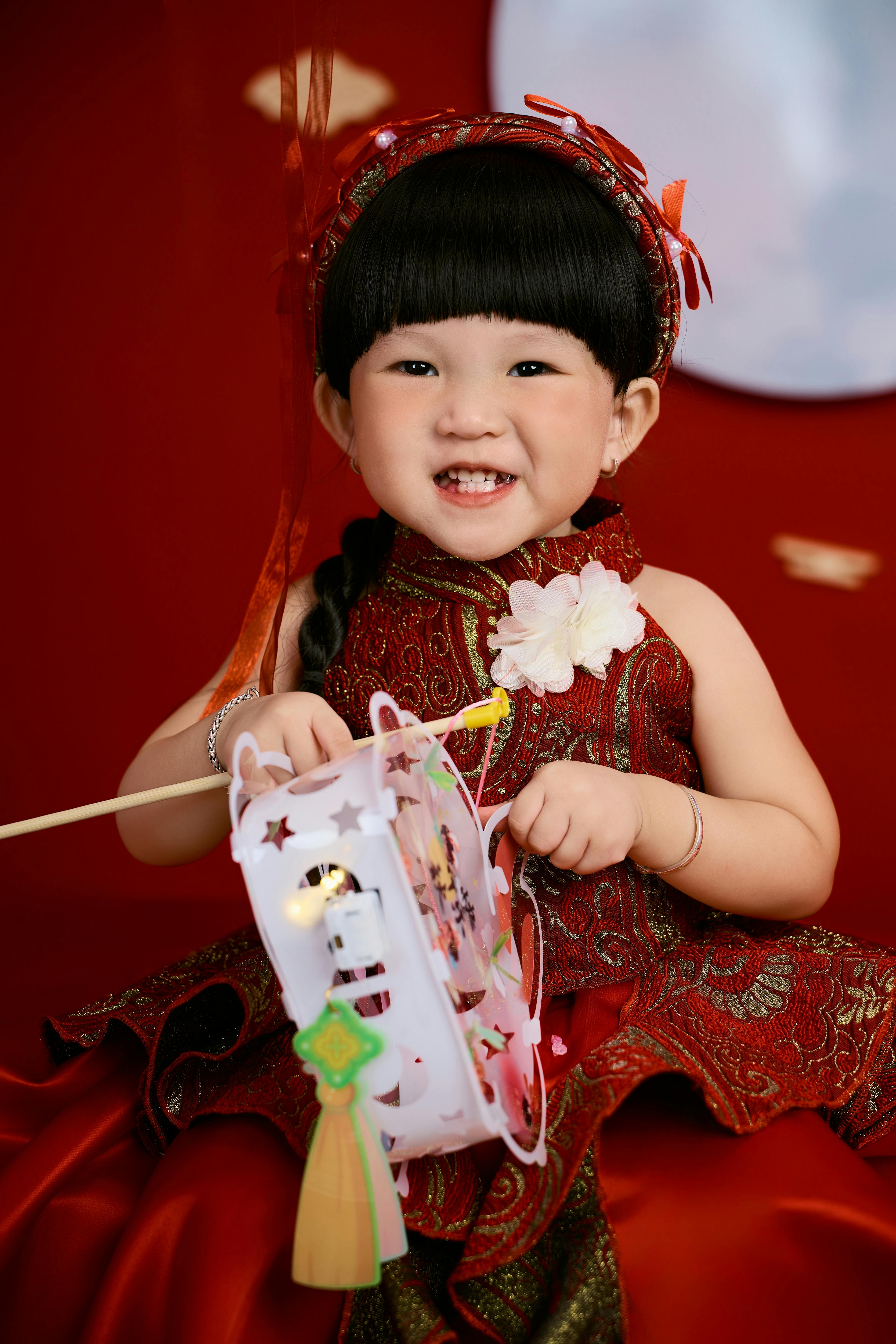 [ColoSach]-a-smiling-child-in-traditional-clothing-holds-a-festive-lantern.