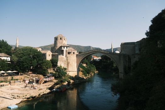 View of the historic Stari Most Bridge in Mostar, Bosnia, showcasing its Ottoman architecture over the Neretva River.