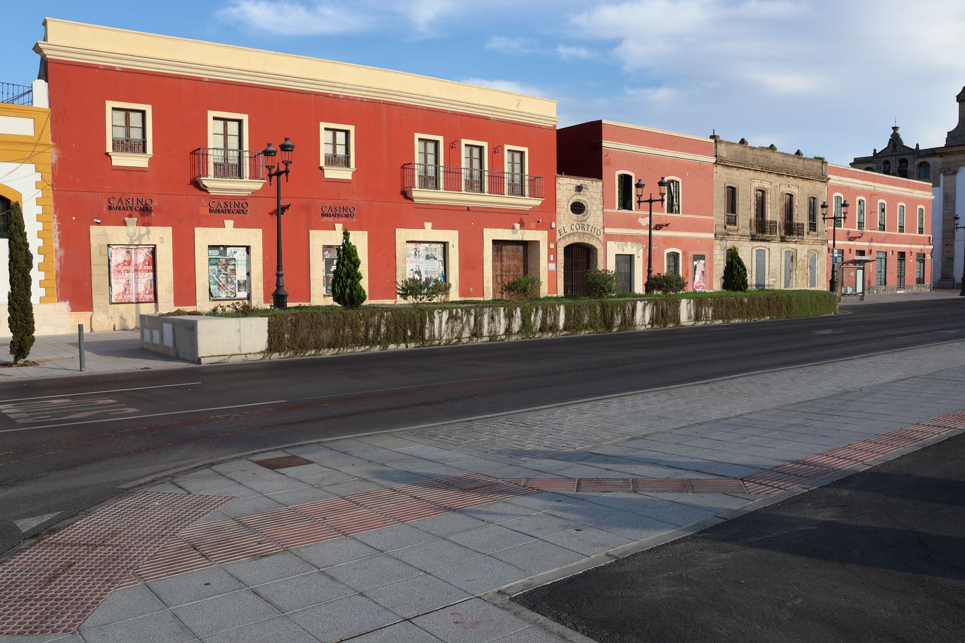 Colorful historic buildings line an empty street in El Puerto de Santa María, Spain.