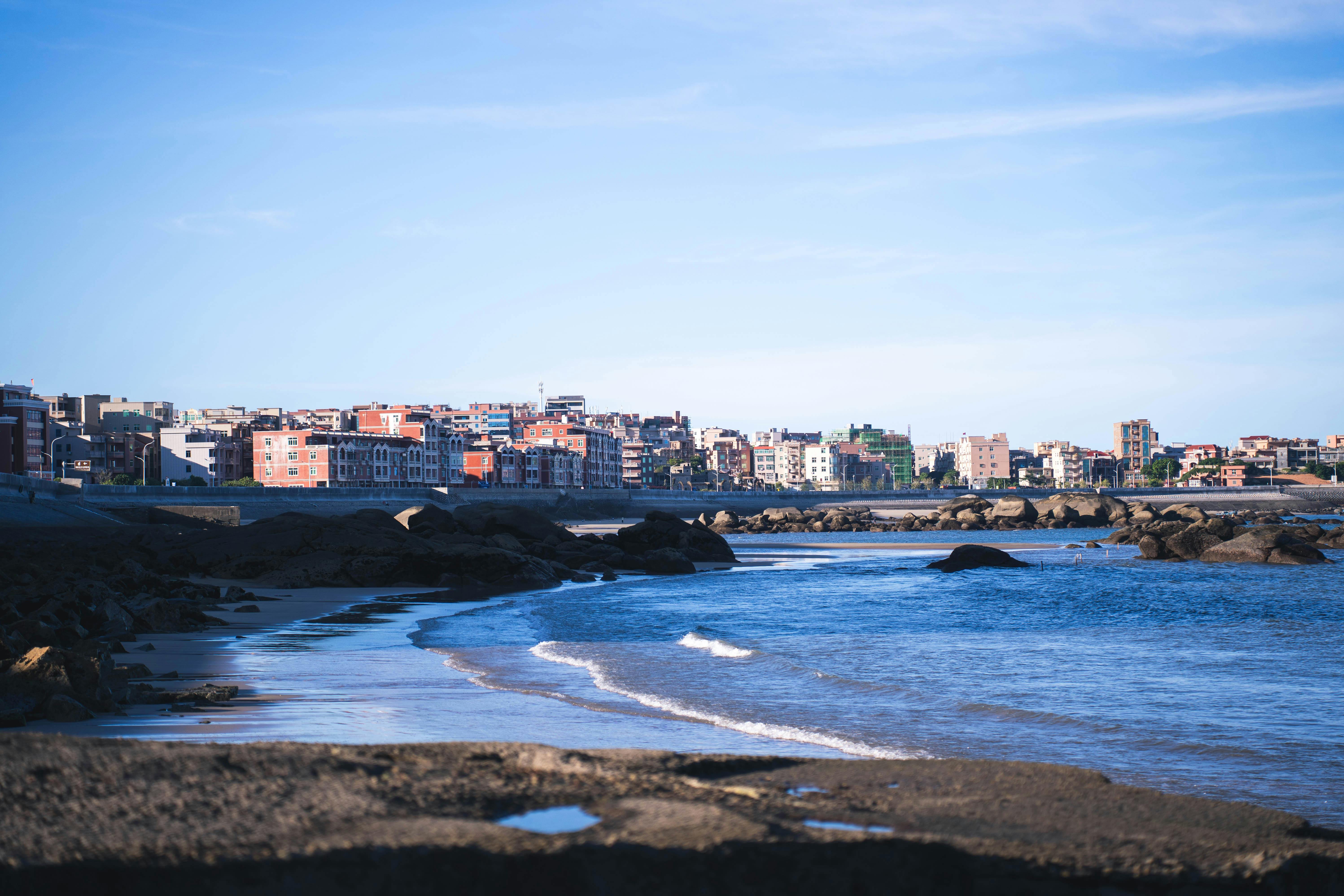 充满活力的沿海城市景观，在蔚蓝的天空下，有沙滩和岩石
