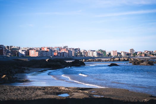 充满活力的沿海城市景观，在蔚蓝的天空下，有沙滩和岩石
