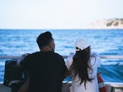 一对夫妇在阳光明媚的日子里享受轻松的乘船之旅，凝视着美丽的海景