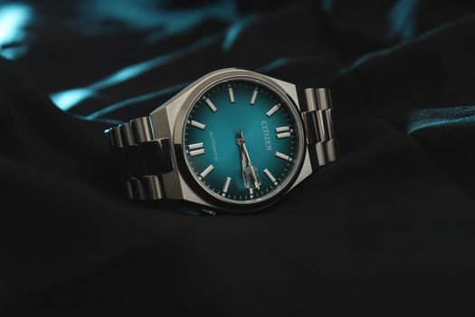 Stylish Citizen automatic wristwatch featuring a striking teal dial and stainless steel bracelet.