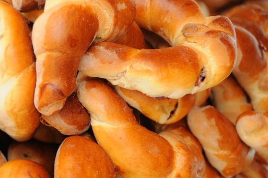 A close-up image of freshly baked golden croissants piled together in a bakery display.