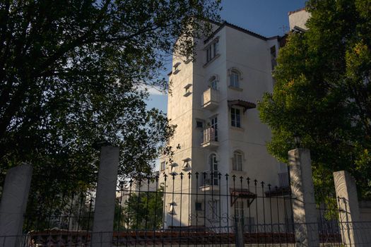 Modern apartment building in sunlight, Kuala Lumpur, surrounded by trees, offering urban living ambiance.
