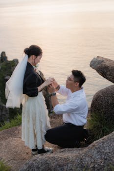 在海边悬崖上，夕阳的余晖洒满了整个天际，为这一刻增添了浪漫的气息