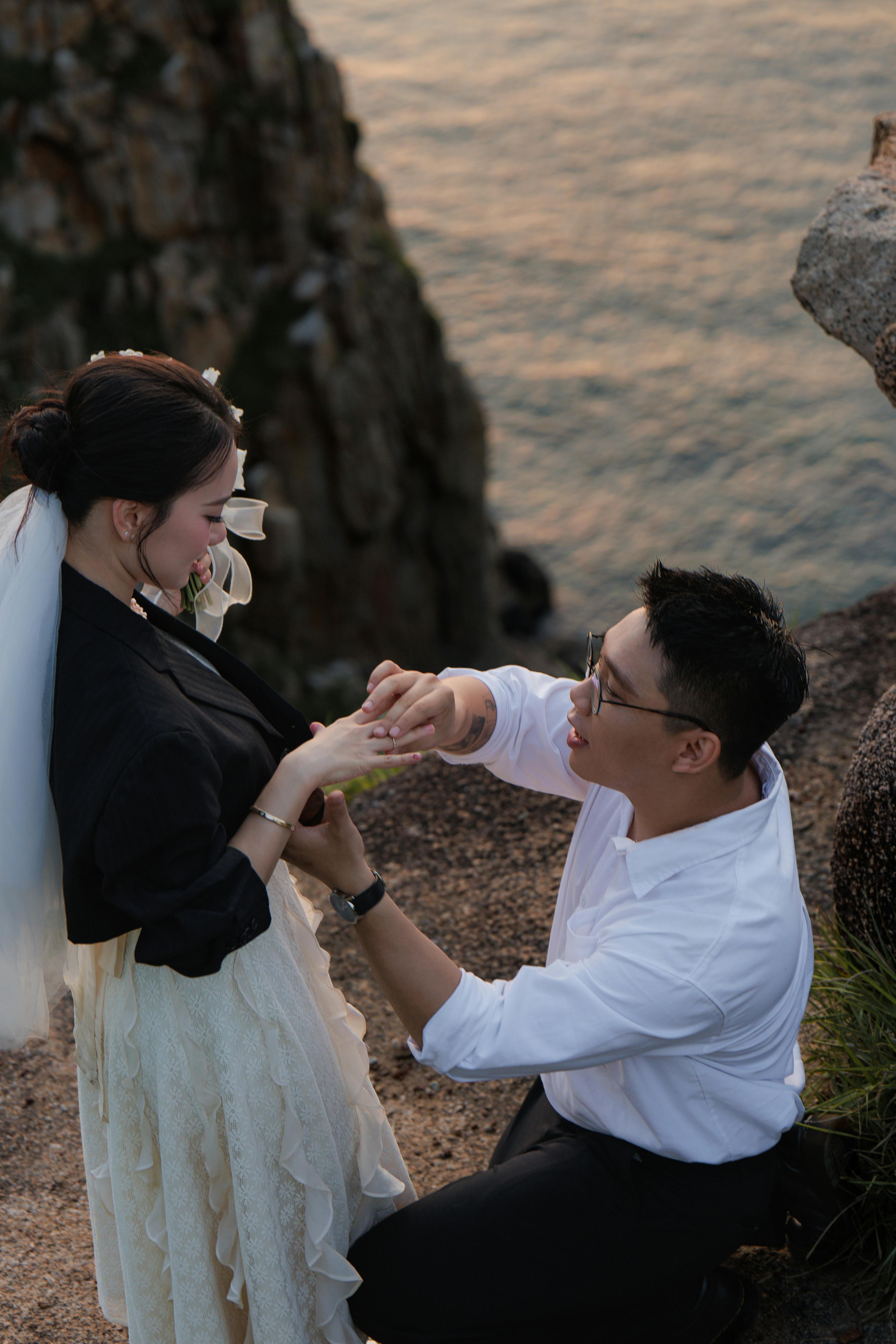 在日落时分，男人在海边向女人求婚，捕捉到了浪漫的时刻