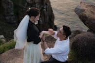 日落时分，一名男子在悬崖边向一名女子求婚，捕捉到浪漫时刻