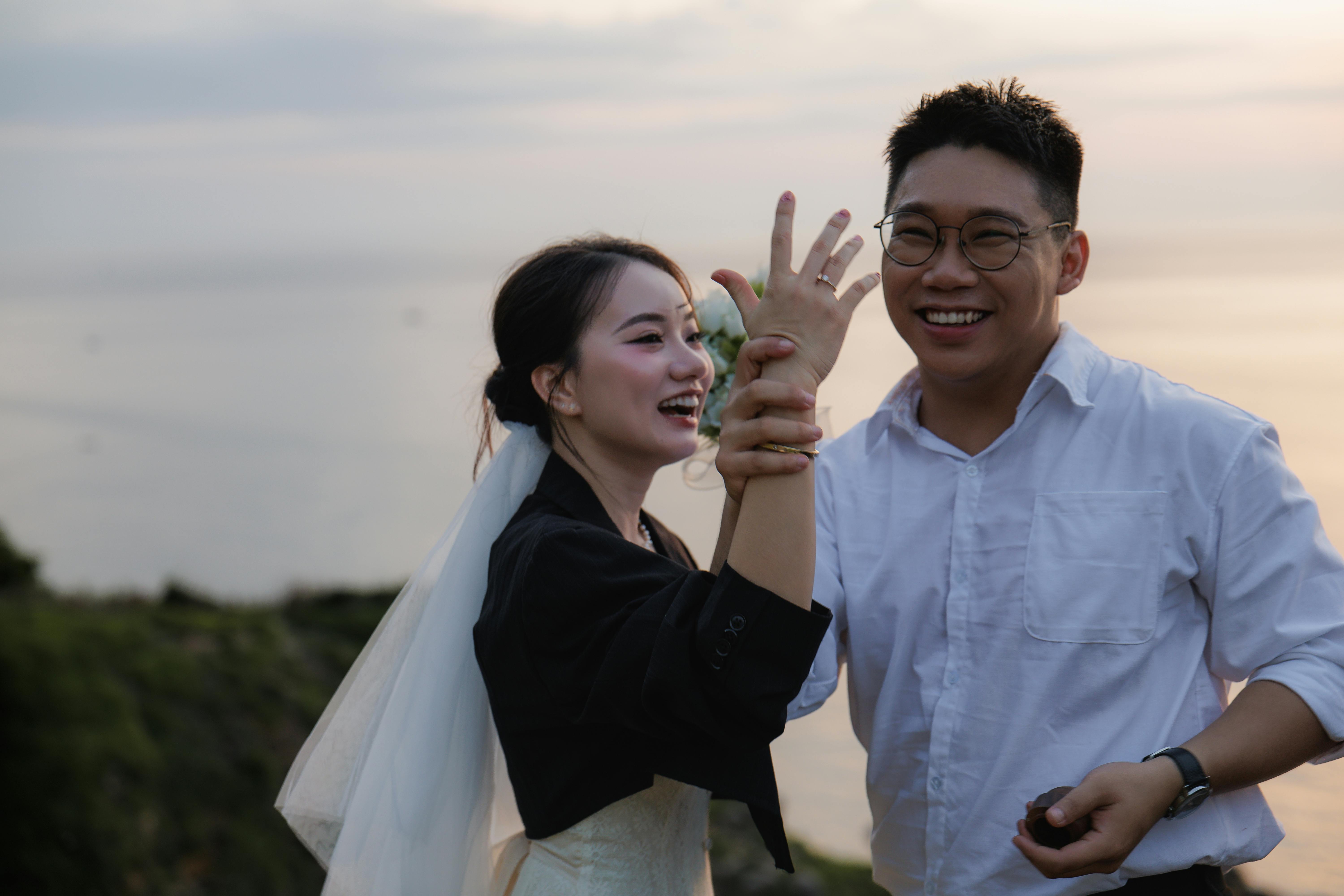 在日落的海边，庆祝他们婚礼的夫妇拥抱着喜悦和爱