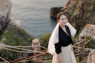 在美丽海景的悬崖边，新娘微笑着，散发着优雅和欢乐