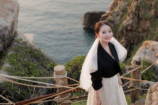 在美丽海景的悬崖边，新娘微笑着，散发着优雅和欢乐