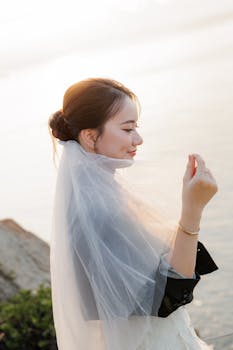 身着优雅婚纱的新娘，在水边享受宁静的日落