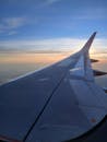 在飞机的窗户前，捕捉那令人惊叹的日落景色，让机翼在鲜艳的天空中显得格外引人注目