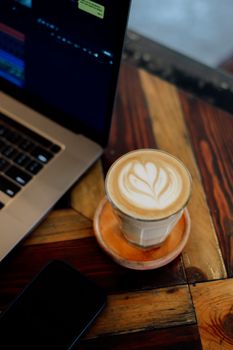 Cozy cafe setting with a flat white coffee near a laptop, perfect for remote work inspiration.
