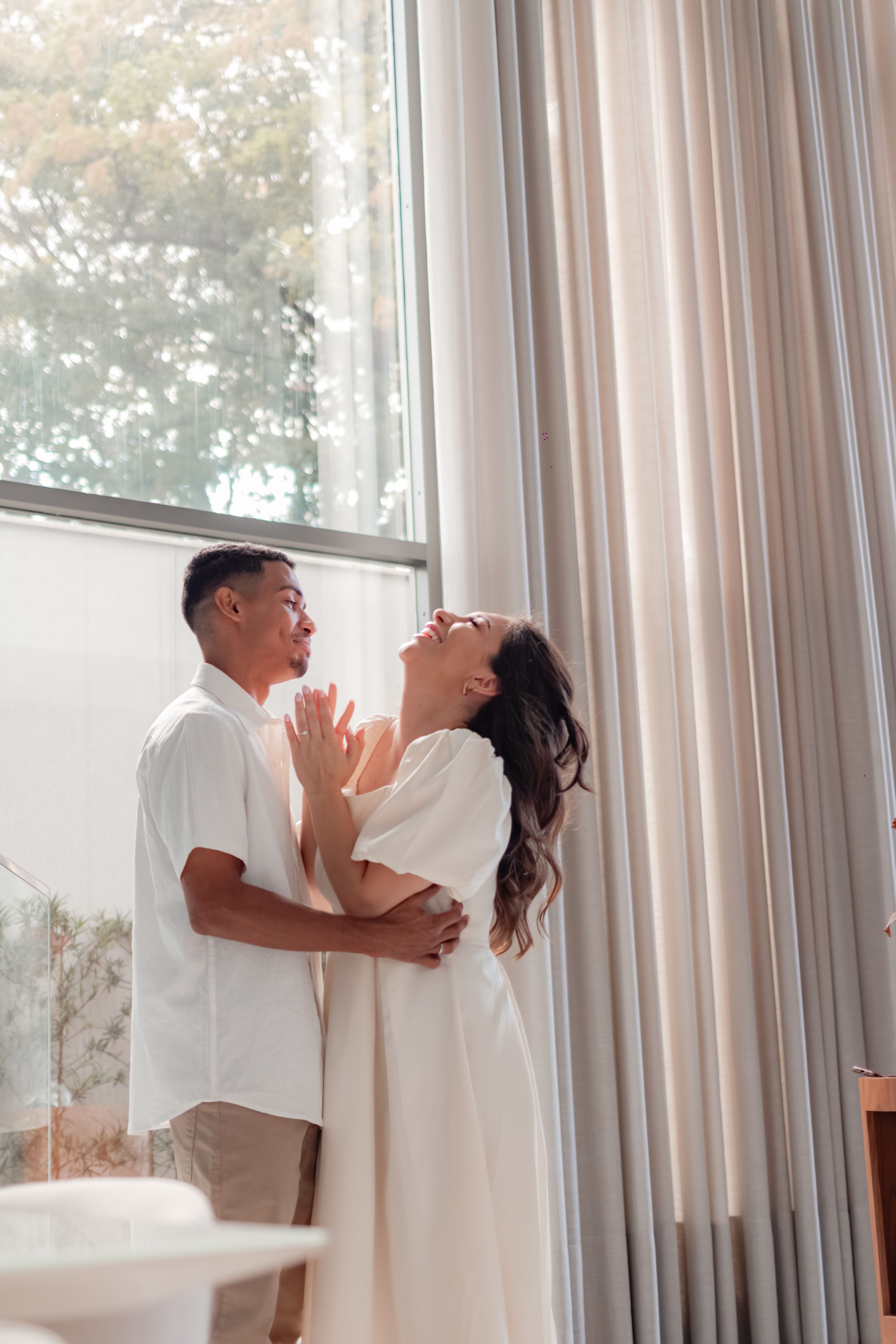 A joyful couple in a bright room sharing a tender moment. Perfect for themes of love and happiness.