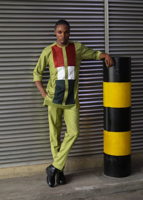 Free Young man in fashionable outfit posing indoors next to a striped pole. Stock Photo