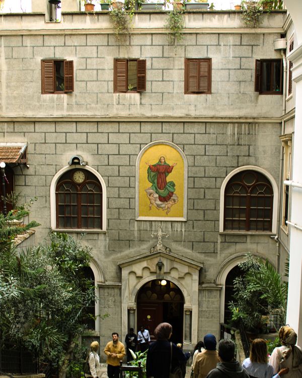 Free An outdoor courtyard featuring historical architecture and a religious mural. Stock Photo