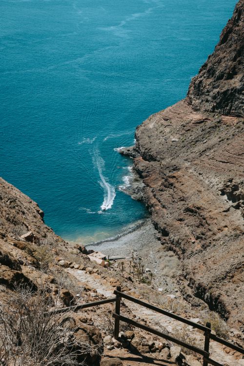 Free Explore the rugged beauty of La Gomera's rocky coastline with turquoise waters and stunning cliffs in the Canary Islands. Stock Photo